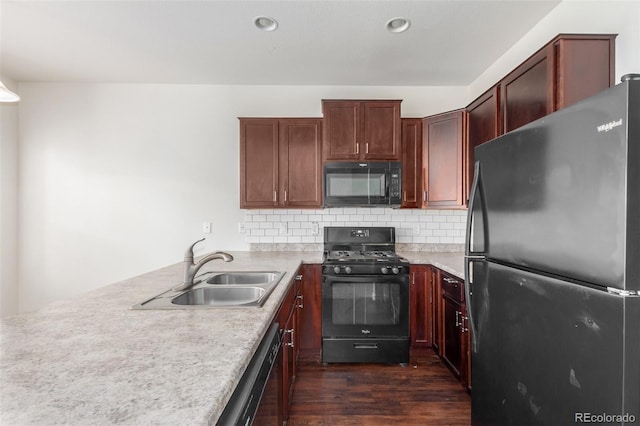 kitchen featuring dark hardwood / wood-style flooring, sink, decorative backsplash, and black appliances