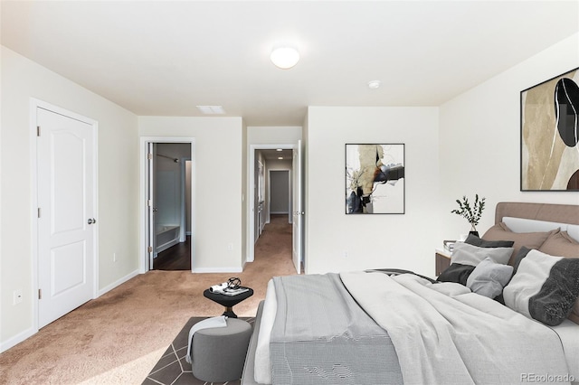 bedroom with connected bathroom and carpet flooring