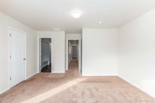 unfurnished bedroom with light colored carpet and ensuite bath