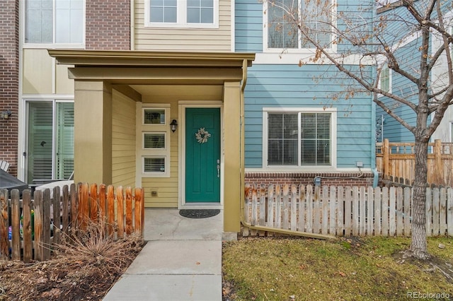 property entrance with brick siding and fence