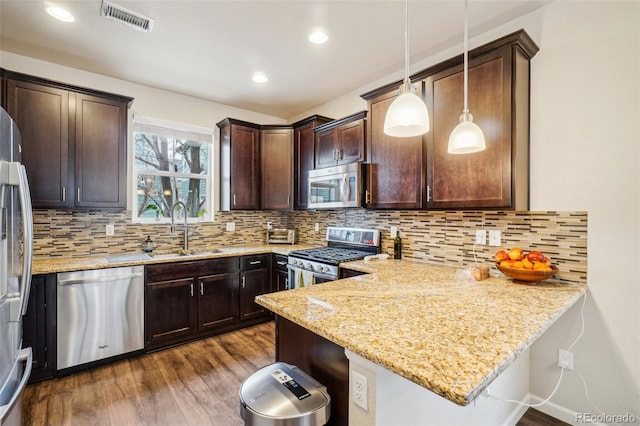 kitchen featuring dark wood-type flooring, a sink, visible vents, dark brown cabinets, and appliances with stainless steel finishes