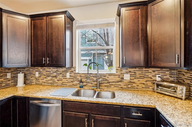 kitchen featuring backsplash, a toaster, dark brown cabinets, and a sink