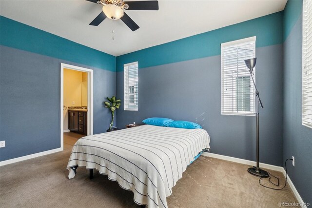 carpeted bedroom with a ceiling fan, baseboards, and ensuite bathroom