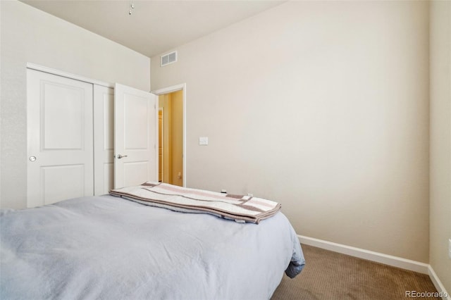 carpeted bedroom with a closet, visible vents, and baseboards