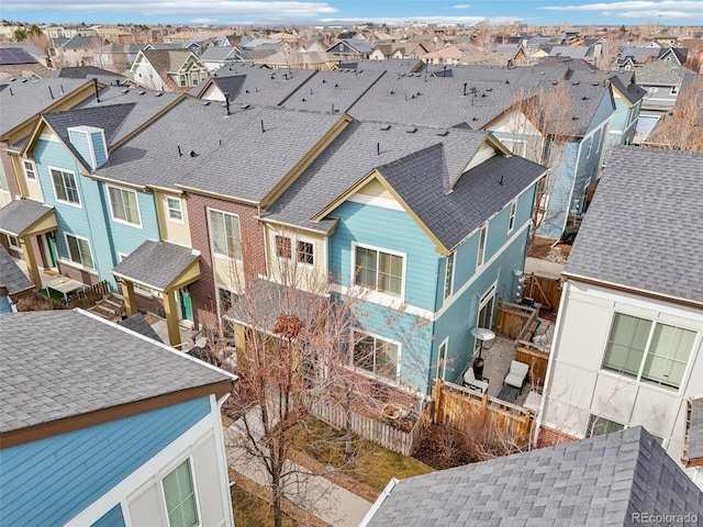 back of property with a shingled roof, a residential view, and fence