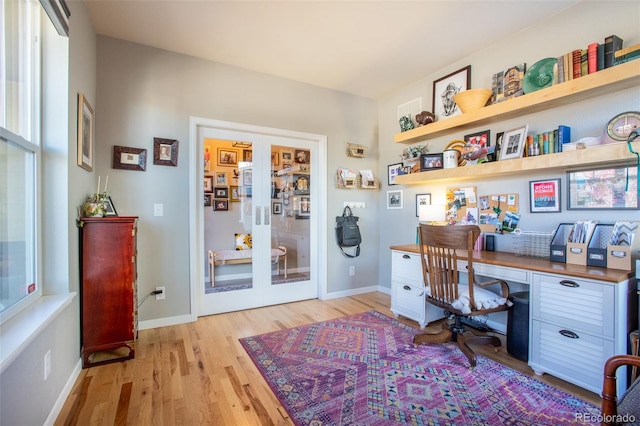 office area with light hardwood / wood-style floors, built in desk, and french doors