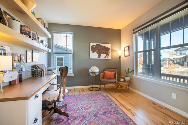 office space featuring built in desk and light hardwood / wood-style floors