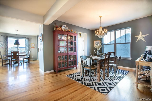 dining space featuring light hardwood / wood-style floors and an inviting chandelier