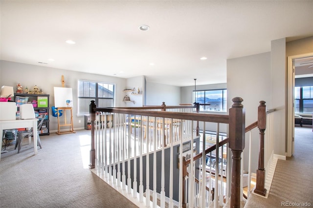 hall featuring light carpet and a wealth of natural light