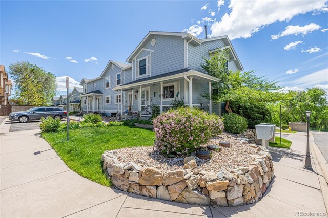 6260 Everett Ct Unit D, Arvada, CO 80004 - view of front of house featuring covered porch and a front yard