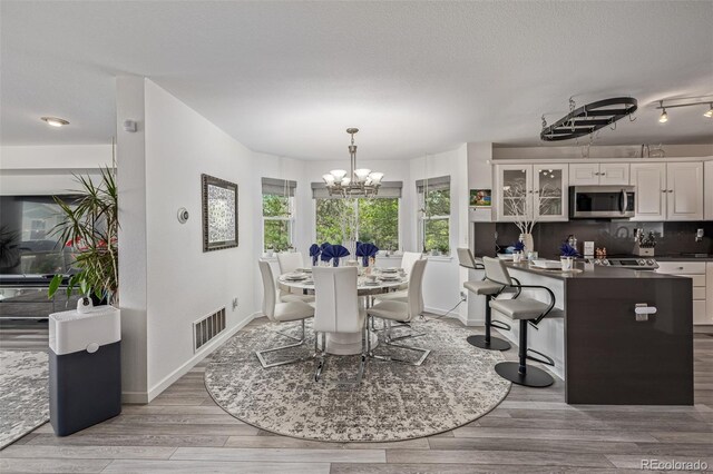 6260 Everett Ct Unit D, Arvada, CO 80004 - dining space featuring a chandelier, light wood finished floors, and baseboards