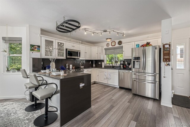 6260 Everett Ct Unit D, Arvada, CO 80004 - kitchen with appliances with stainless steel finishes, dark countertops, wood finished floors, and white cabinetry