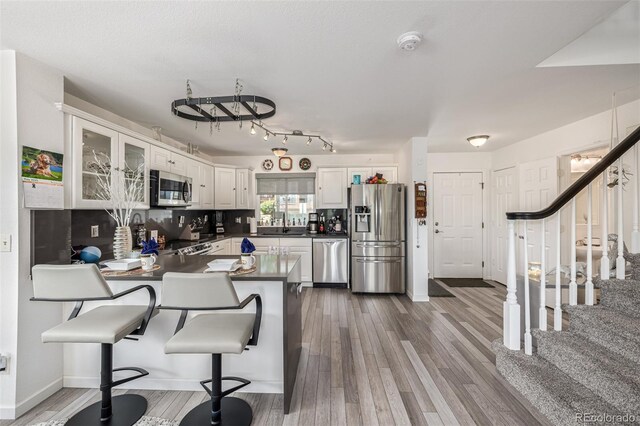 6260 Everett Ct Unit D, Arvada, CO 80004 - kitchen featuring stainless steel appliances, dark countertops, a peninsula, and dark wood-type flooring
