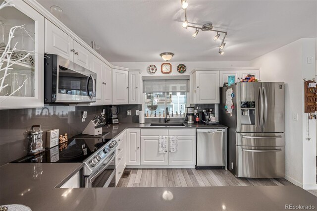 6260 Everett Ct Unit D, Arvada, CO 80004 - kitchen featuring stainless steel appliances, a sink, dark countertops, and white cabinets