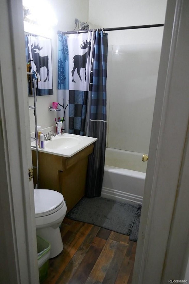 full bathroom featuring vanity, shower / bathtub combination with curtain, hardwood / wood-style floors, and toilet