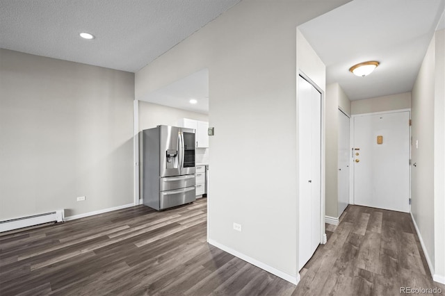 interior space with dark wood-style floors, recessed lighting, a baseboard radiator, and baseboards