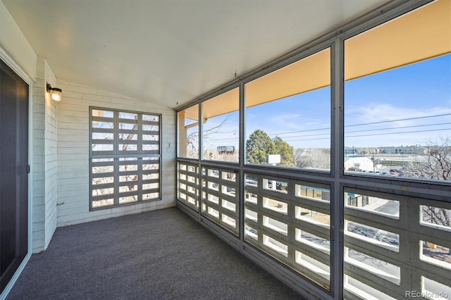 unfurnished sunroom featuring vaulted ceiling