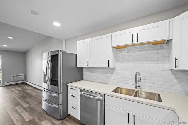 kitchen with stainless steel appliances, dark wood-style flooring, a sink, white cabinets, and light countertops