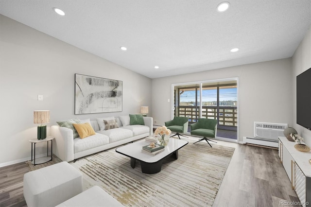 living area with recessed lighting, wood finished floors, and a wall mounted AC