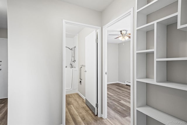 hall with a baseboard radiator and wood finished floors