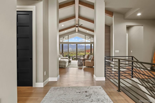 entrance foyer featuring ceiling fan, high vaulted ceiling, beamed ceiling, and light wood-type flooring