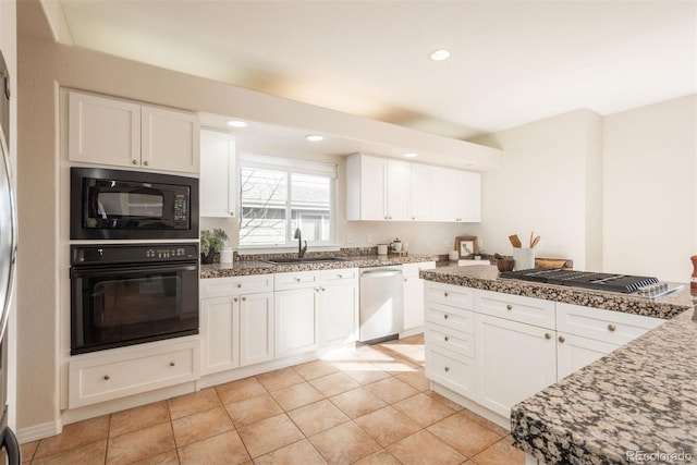 kitchen with sink, white cabinets, light tile patterned floors, light stone counters, and black appliances