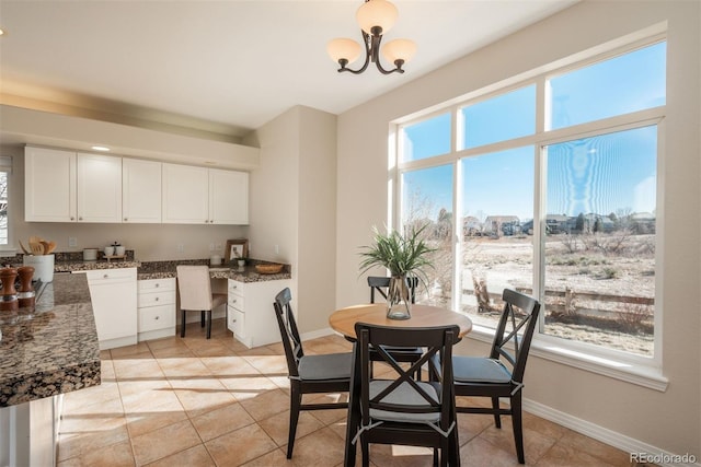 tiled dining area featuring built in desk and a chandelier