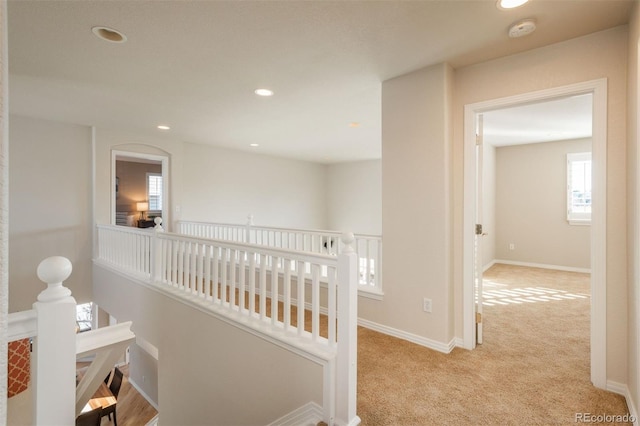 hall with light colored carpet