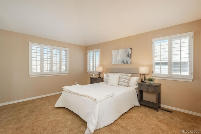 bedroom featuring multiple windows and light carpet