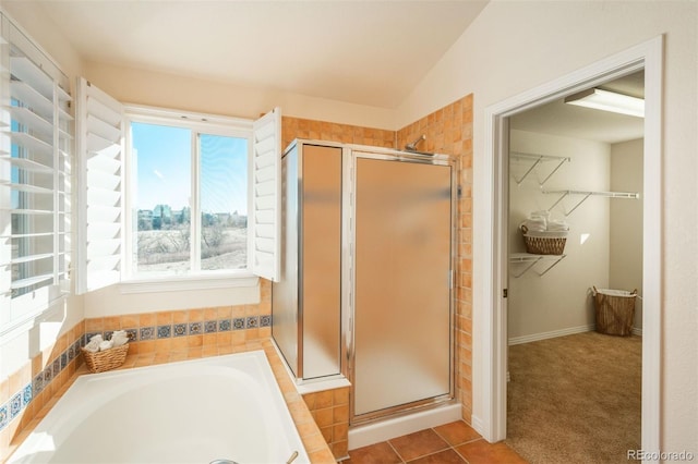 bathroom with independent shower and bath, vaulted ceiling, and tile patterned floors