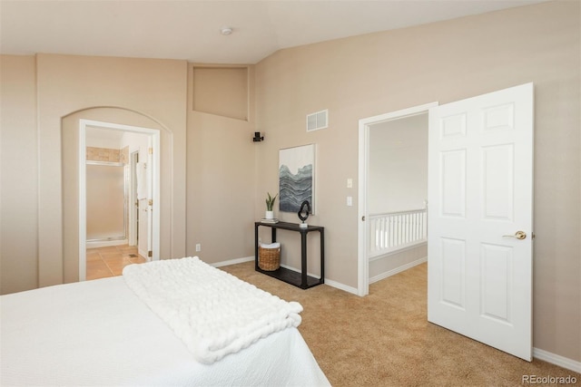 bedroom with vaulted ceiling and light colored carpet