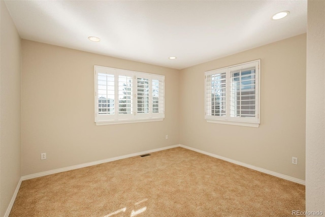 spare room featuring light colored carpet