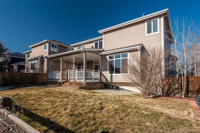 rear view of property featuring a yard, covered porch, and a patio area