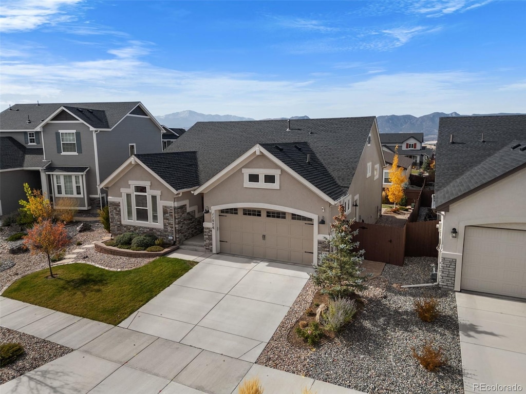 view of front of property featuring a mountain view, a garage, and a front lawn