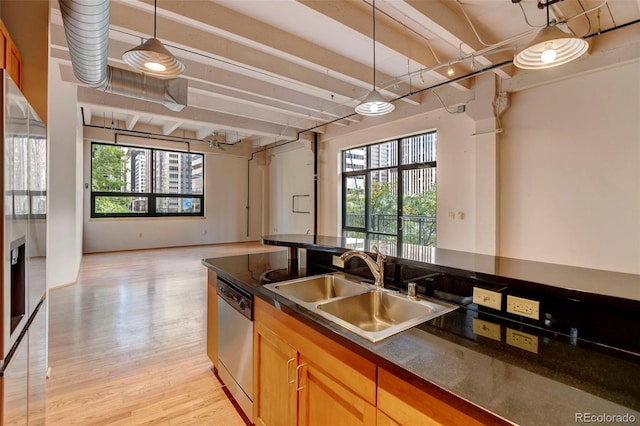 kitchen featuring a sink, a healthy amount of sunlight, dark countertops, and stainless steel appliances