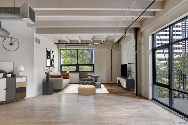 living area featuring visible vents, a wealth of natural light, and wood finished floors