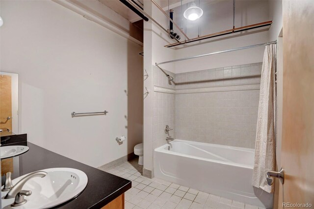 bathroom featuring tile patterned flooring, shower / bath combo with shower curtain, vanity, and toilet