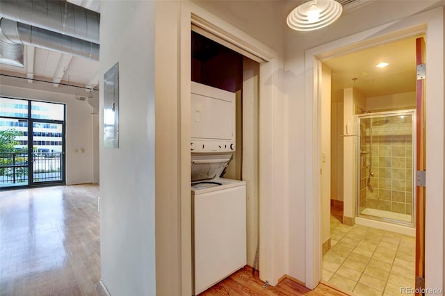 laundry room featuring light wood-style floors, stacked washer and dryer, and laundry area