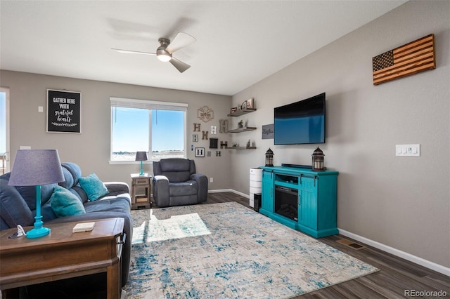 living room with ceiling fan and dark hardwood / wood-style flooring