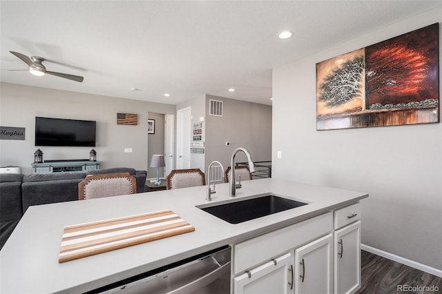 kitchen with ceiling fan, sink, dark hardwood / wood-style flooring, stainless steel dishwasher, and white cabinets