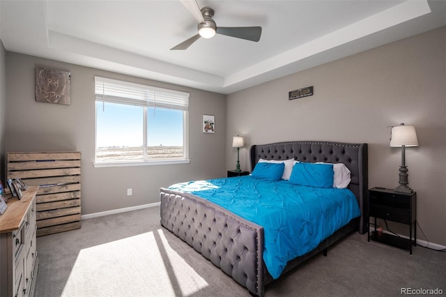 bedroom with a tray ceiling, ceiling fan, and light colored carpet