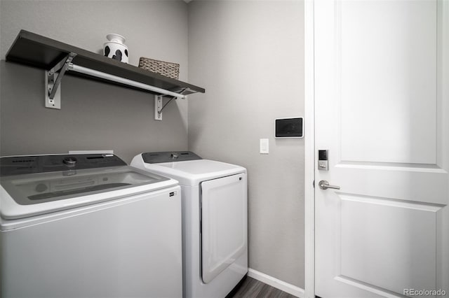 clothes washing area with dark hardwood / wood-style flooring and independent washer and dryer