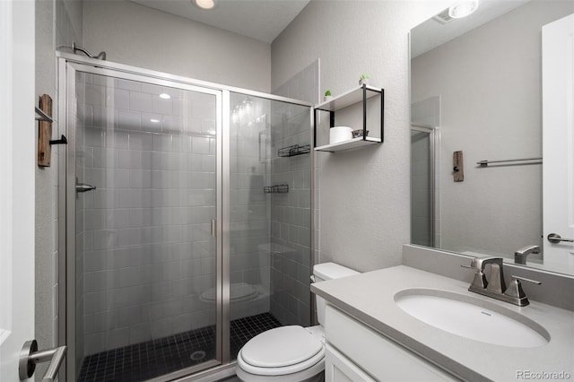 bathroom with vanity, toilet, and a shower with door