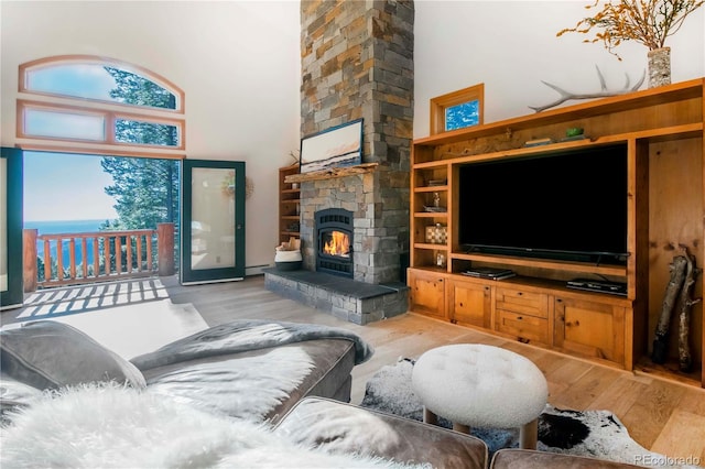 13416 Kuehster Rd, Littleton, CO 80127 - living area with wood finished floors, a stone fireplace, and a towering ceiling