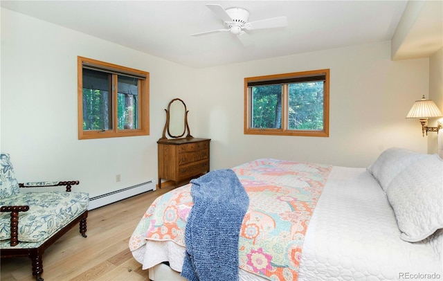13416 Kuehster Rd, Littleton, CO 80127 - bedroom featuring a baseboard heating unit, multiple windows, wood finished floors, and a ceiling fan