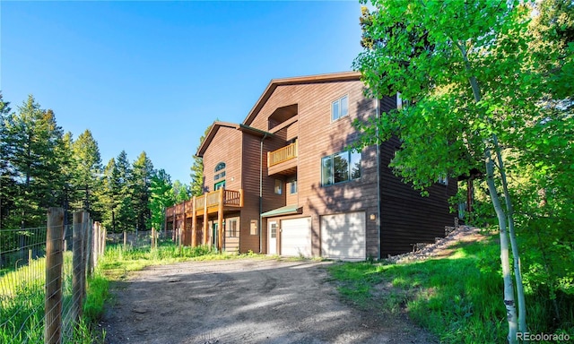 13416 Kuehster Rd, Littleton, CO 80127 - view of front of property featuring a balcony, an attached garage, and driveway