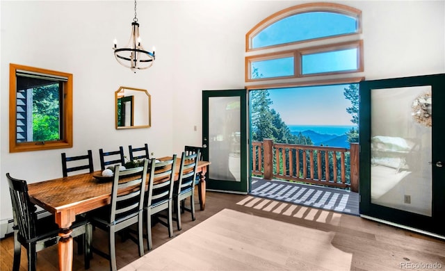 13416 Kuehster Rd, Littleton, CO 80127 - dining space featuring a chandelier, a towering ceiling, and wood finished floors