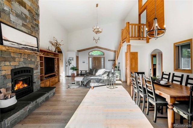 13416 Kuehster Rd, Littleton, CO 80127 - dining space featuring a chandelier, high vaulted ceiling, a fireplace, and wood finished floors
