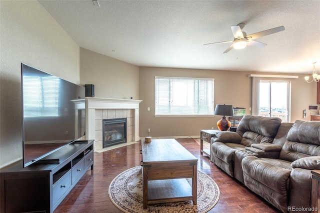 6265 S Ider Way, Aurora, CO 80016 - living area featuring healthy amount of natural light, dark wood-style flooring, a ceiling fan, a tile fireplace, and a textured ceiling
