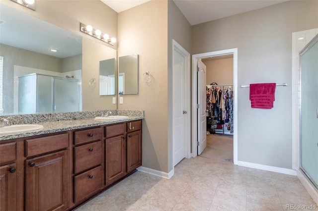 6265 S Ider Way, Aurora, CO 80016 - full bathroom featuring a shower stall, double vanity, a spacious closet, and baseboards